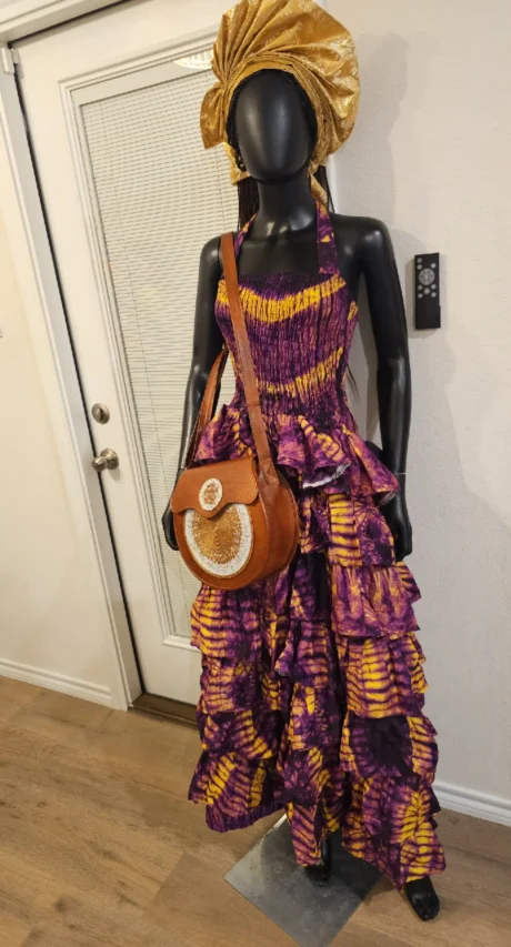 The Zola Cocoa Step Ruffle Smokey Maxi Dress is a stunning blend of rich brown smokey Ankara tones and elegant step-ruffle detailing. Designed to flatter sizes 8–16, this maxi dress flows beautifully with every step, offering comfort, movement, and effortless sophistication. Perfect for special occasions or elevated everyday wear, it’s a timeless statement piece that celebrates culture with refined style.