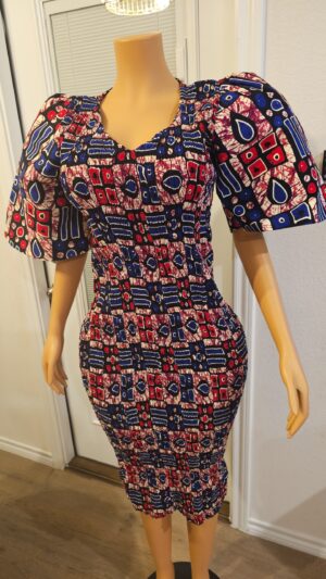 Model wearing a smokey Ankara dress featuring rich muted tones, bold African print, and a flowing, elegant silhouette