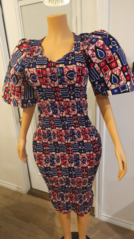 Model wearing a smokey Ankara dress featuring rich muted tones, bold African print, and a flowing, elegant silhouette